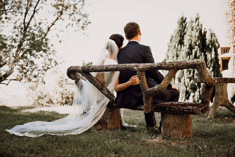 Photo naturelle des mariés assis en extérieur pendant une séance couple mariage